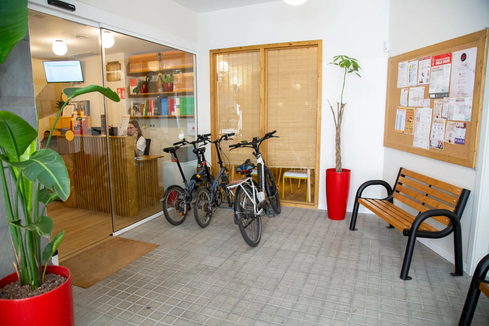 Entrada de la escuela BCNLIP UP en Barcelona con bicicletas aparcadas, recepción y zona de espera.