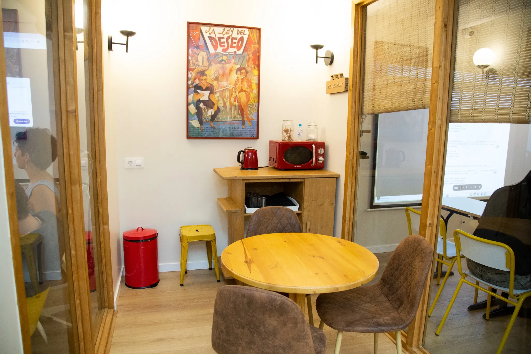 Zona de descanso con microondas, hervidor y mesa en la escuela de idiomas BCNLIP UP en Barcelona.