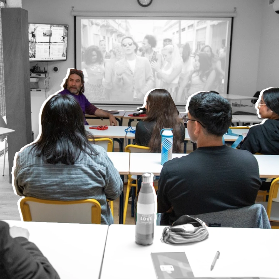 Profesor y estudiantes en un aula de BCNLIP UP durante una proyección audiovisual.